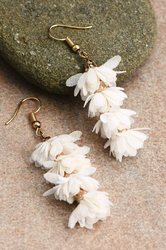 Boho Fabric Flower Drop Earrings from The Swanky Bee Jewelry, featuring delicate white fabric petals and gold-tone hooks for a chic bohemian look.