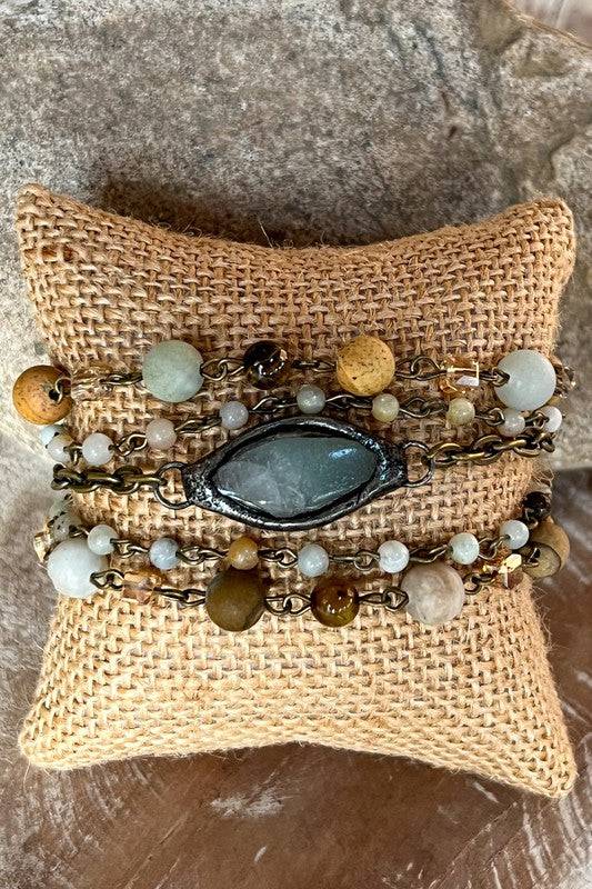 Buy Emory Bracelet 5 strand design featuring earthy-toned beads and a central gemstone. Adjustable clasp for a perfect fit.