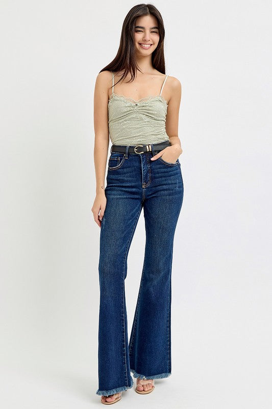 Model wearing tummy control high rise flare jeans with frayed hem.