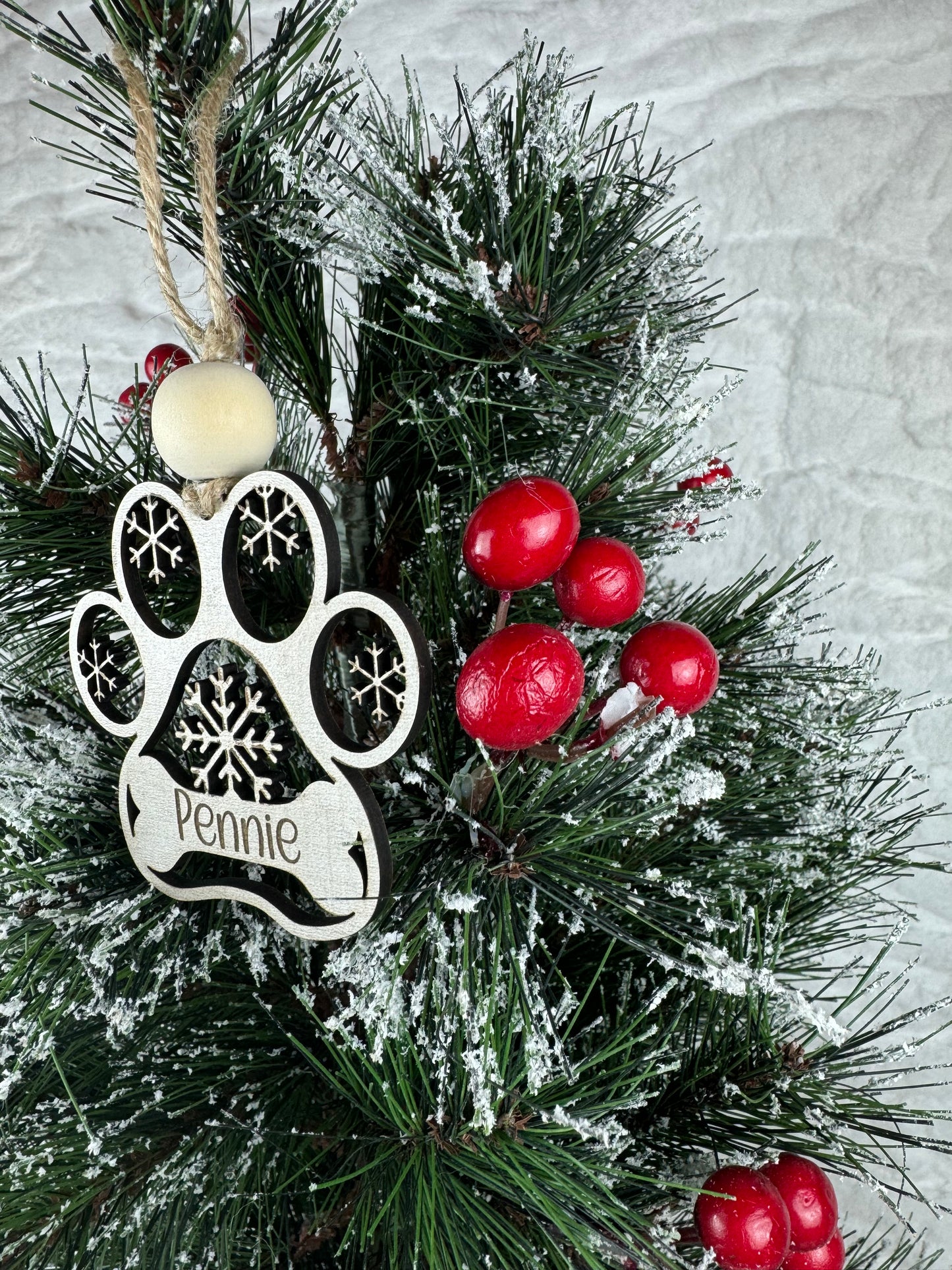 Dog paw ornament with name on snowy tree