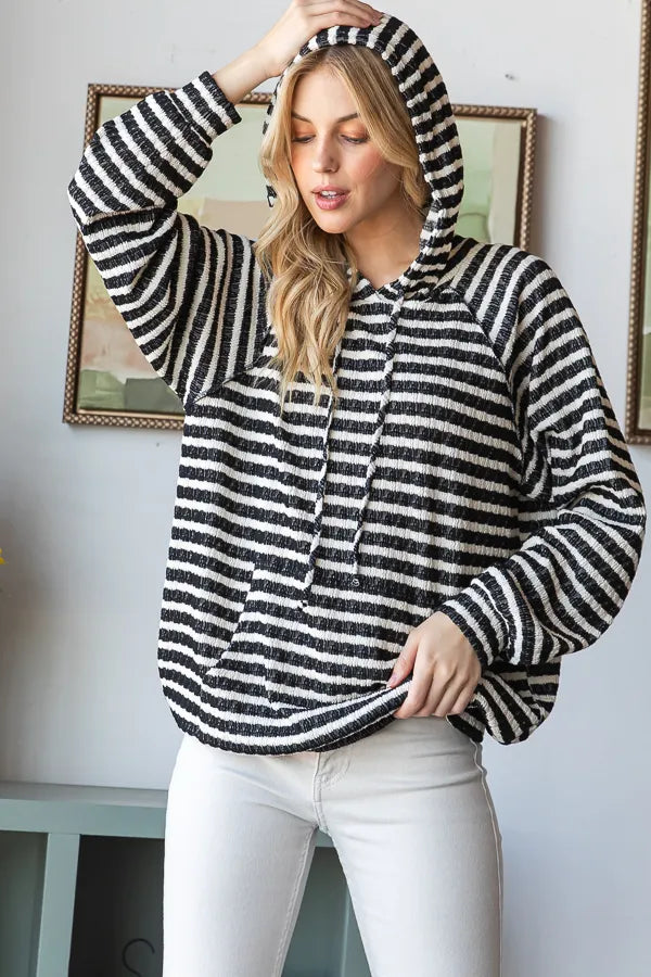 Model wearing striped puff sleeve hoodie with hood up
